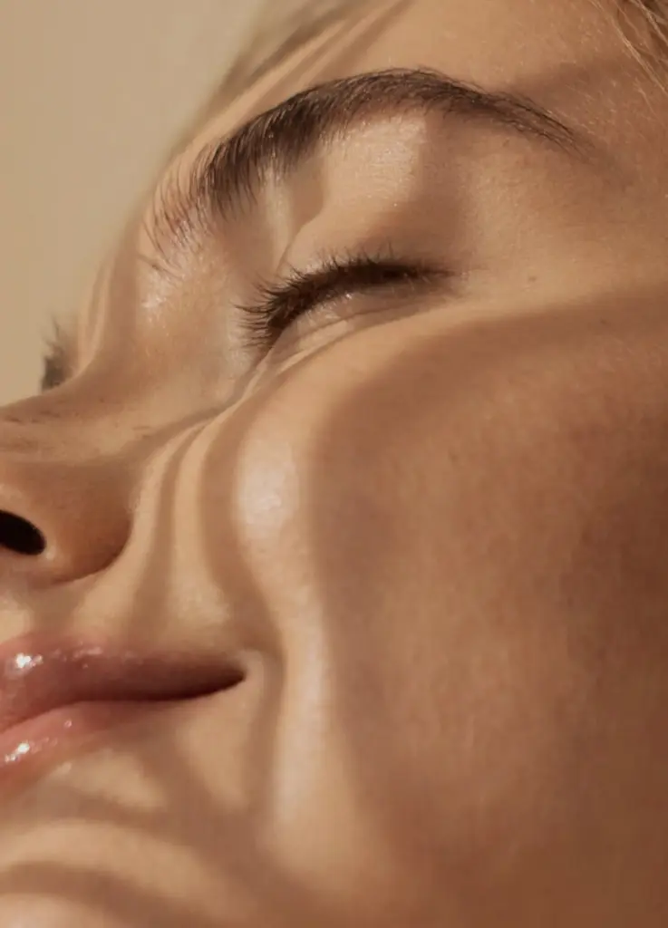 Eine schöne Frau genießt die Sonnenstrahlen - ganzheitliche Sonnenpflege bei Claresco Cosmetic